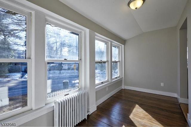 unfurnished sunroom featuring vaulted ceiling and radiator