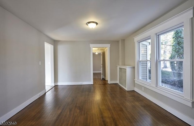 empty room with dark hardwood / wood-style flooring