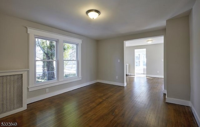 empty room featuring radiator and dark wood-type flooring