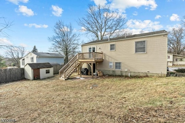 rear view of house with a yard, a shed, and a wooden deck