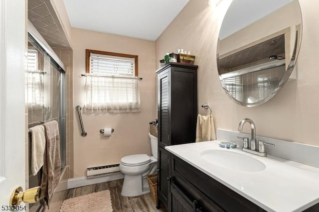 bathroom with hardwood / wood-style floors, vanity, toilet, and a baseboard heating unit