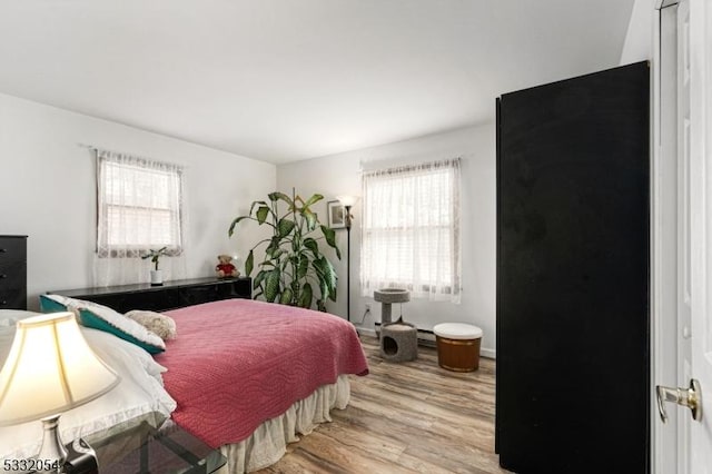 bedroom with light hardwood / wood-style flooring and multiple windows