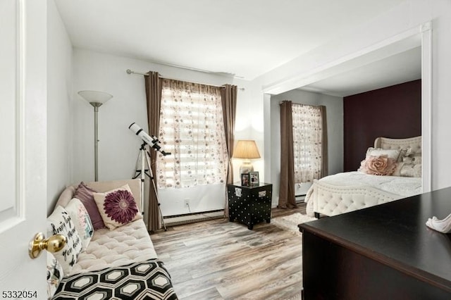 bedroom featuring light hardwood / wood-style floors and a baseboard radiator