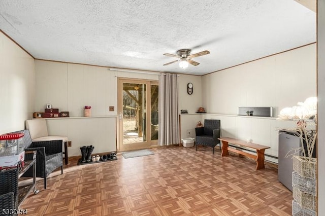 living area with ceiling fan, parquet floors, and a textured ceiling