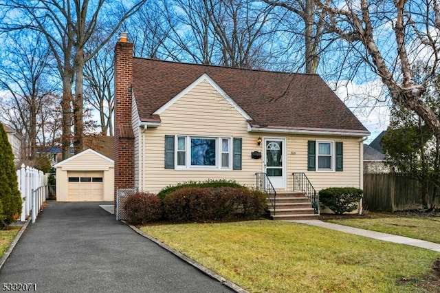 view of front of property featuring an outbuilding, a front yard, and a garage