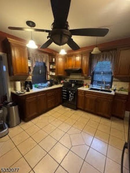 kitchen with ceiling fan, black stove, light tile patterned floors, and decorative light fixtures