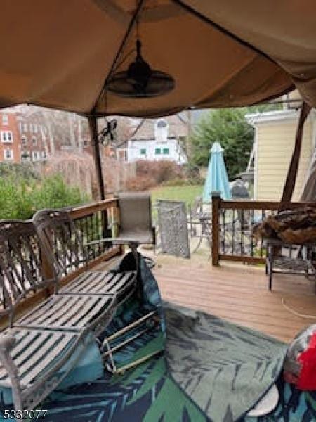 wooden terrace featuring a gazebo and ceiling fan