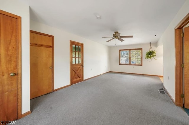 spare room featuring carpet floors, visible vents, and baseboards