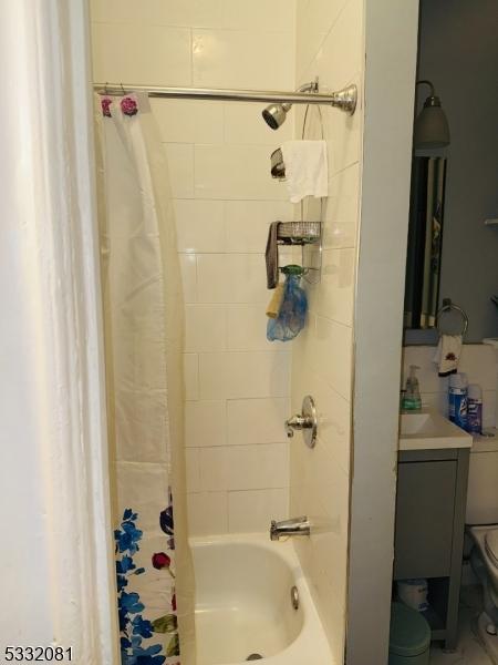 bathroom with toilet and shower / tub combo