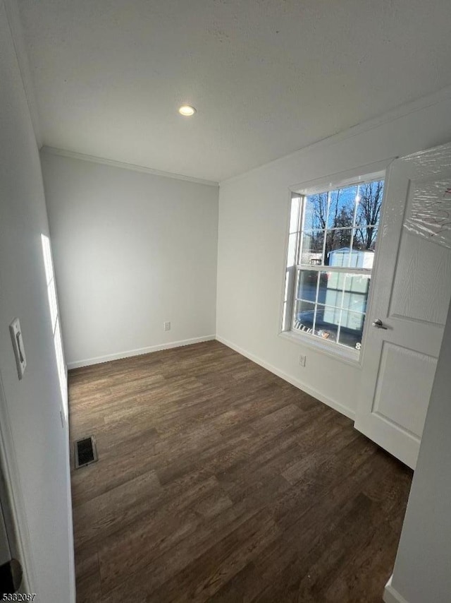 spare room featuring dark hardwood / wood-style floors and ornamental molding