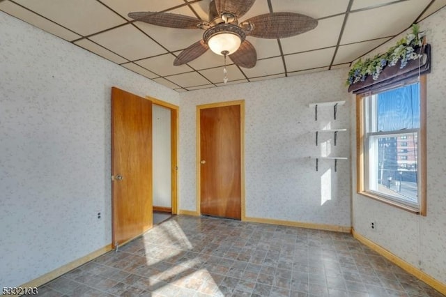 unfurnished room with a drop ceiling and ceiling fan