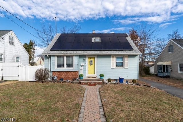 bungalow-style house with solar panels and a front yard