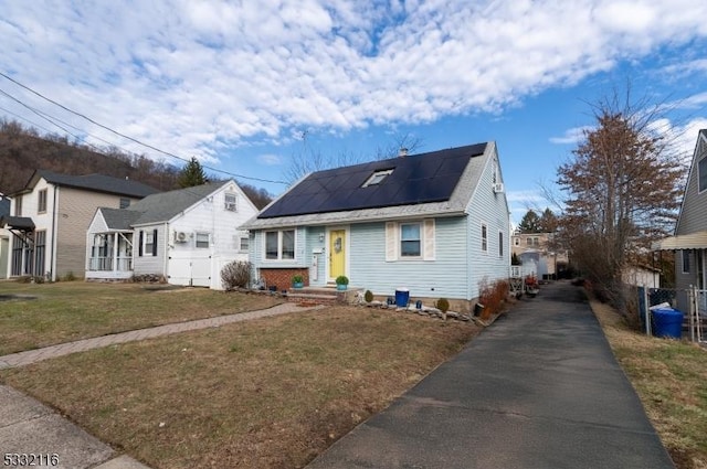 bungalow-style home with a front lawn and solar panels