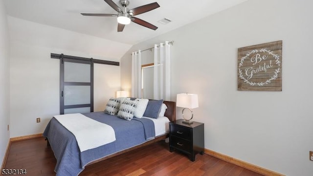 bedroom with lofted ceiling, dark wood-type flooring, ceiling fan, and a barn door