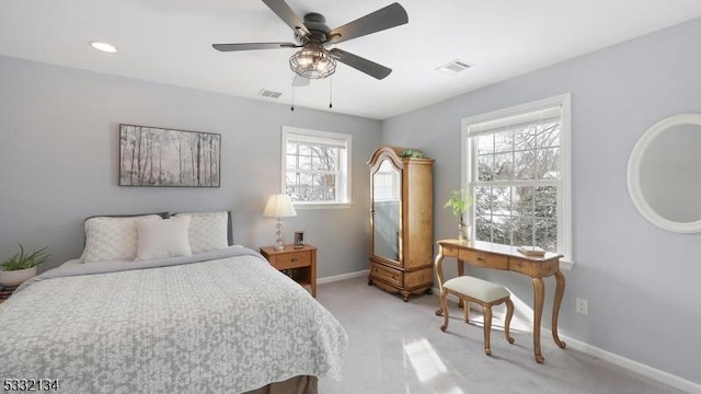 bedroom featuring light carpet, multiple windows, and ceiling fan