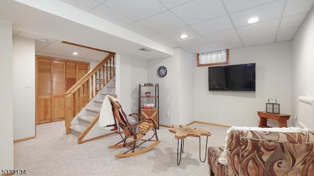 carpeted living room with a paneled ceiling