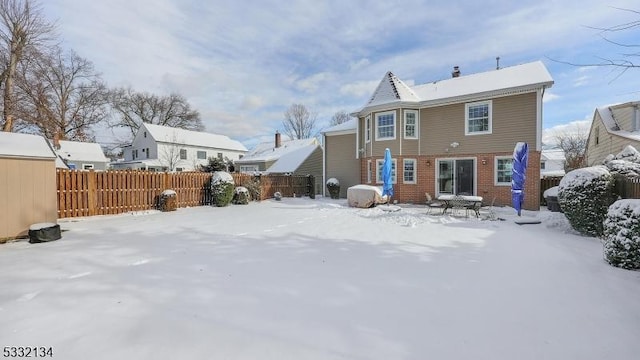 view of snow covered back of property