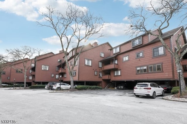 snow covered property featuring uncovered parking