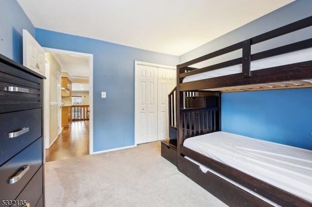 bedroom featuring baseboards, a closet, and light colored carpet