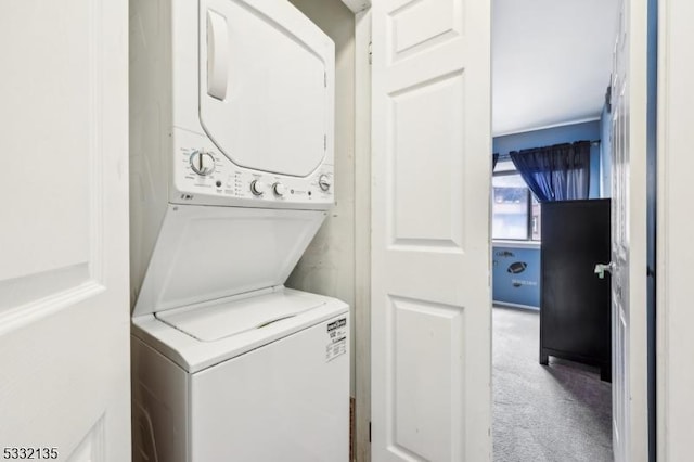 clothes washing area with stacked washer and dryer, carpet, and laundry area