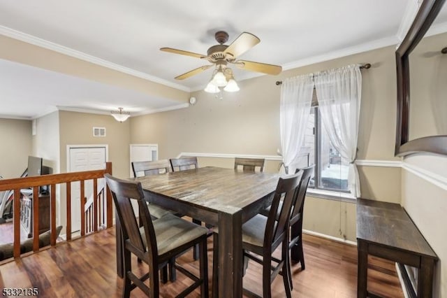 dining area with crown molding, dark hardwood / wood-style flooring, and ceiling fan