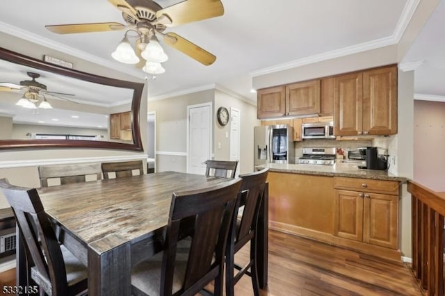 dining area featuring dark wood-style floors, ornamental molding, and ceiling fan