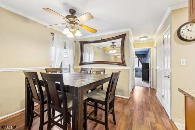 dining space with ceiling fan, wood-type flooring, and ornamental molding