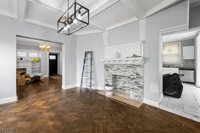 living room featuring an inviting chandelier, a stone fireplace, parquet floors, crown molding, and beamed ceiling