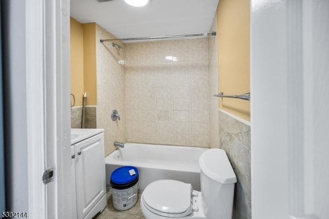 full bathroom with toilet, vanity, tile walls, and tiled shower / bath