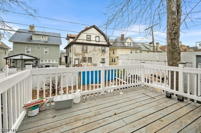 wooden deck featuring a swimming pool and a gazebo