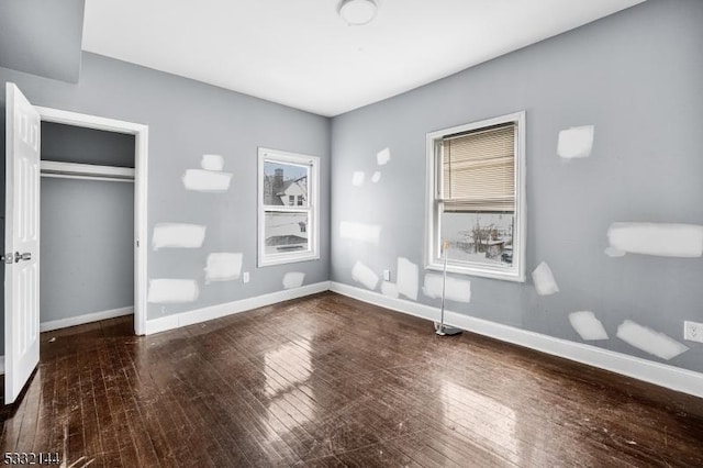 unfurnished bedroom with wood-type flooring and a closet