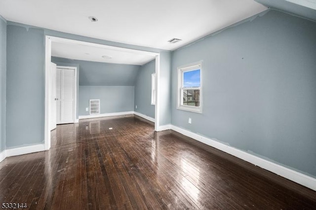 additional living space featuring dark hardwood / wood-style floors and vaulted ceiling