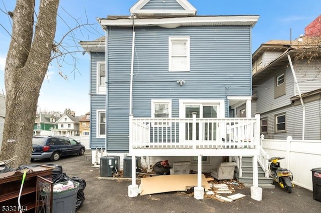 rear view of house with a deck and central AC unit