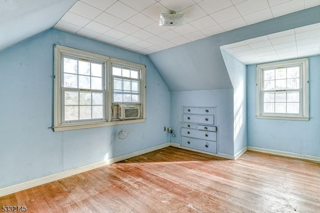 bonus room featuring cooling unit, lofted ceiling, and light hardwood / wood-style flooring