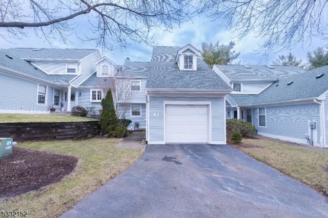 cape cod home with a garage and a front lawn