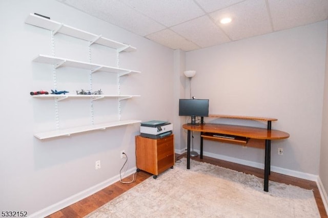 office space with a paneled ceiling and light hardwood / wood-style floors