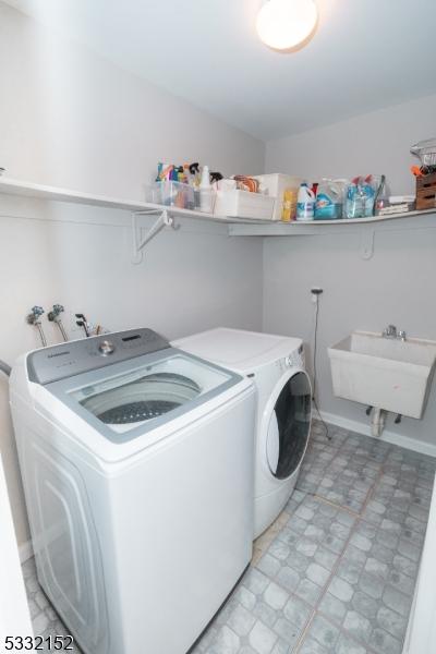 clothes washing area with sink and washing machine and clothes dryer