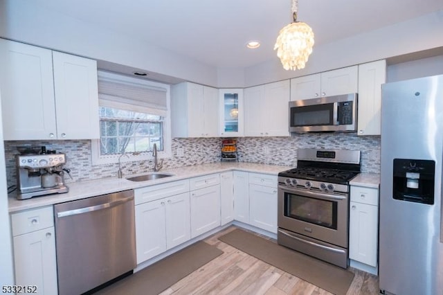 kitchen with tasteful backsplash, white cabinets, sink, and stainless steel appliances