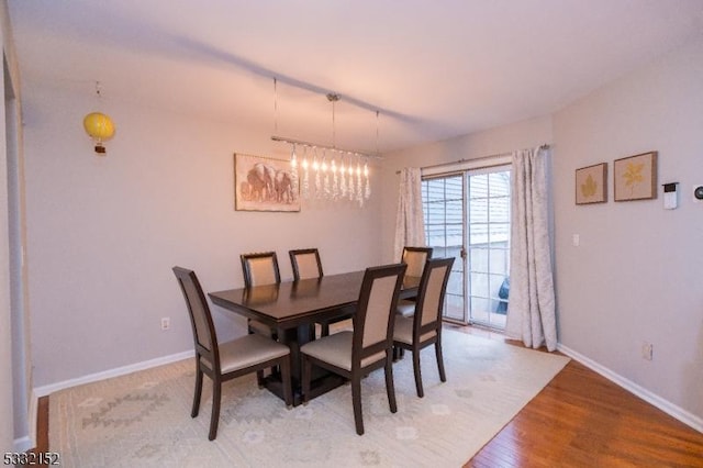 dining space featuring an inviting chandelier and wood-type flooring