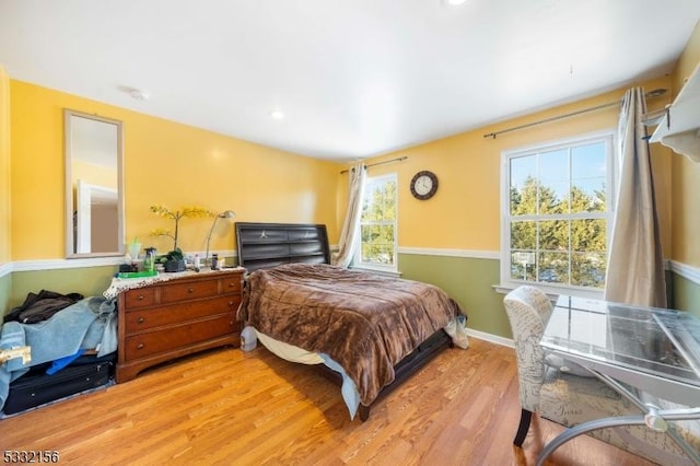 bedroom featuring multiple windows and light hardwood / wood-style flooring