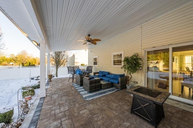 snow covered patio featuring an outdoor living space and ceiling fan