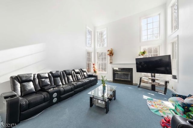 living room featuring carpet flooring and a towering ceiling