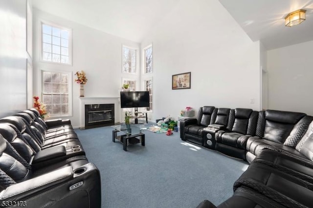 living room with carpet flooring, a fireplace, and a towering ceiling