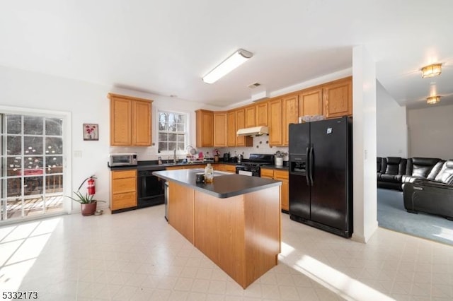 kitchen with sink, a kitchen island, and black appliances