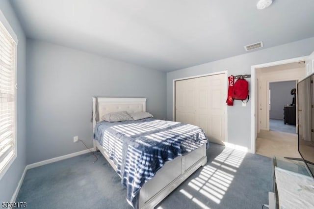 bedroom with a closet and dark colored carpet