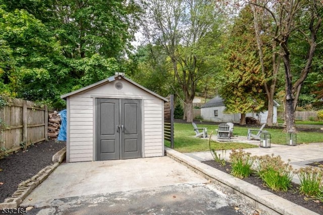 view of outbuilding with a fire pit and a yard