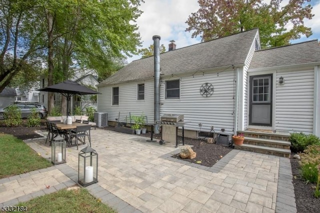 back of property with cooling unit and a patio