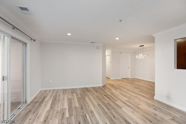 spare room with an inviting chandelier, light wood-type flooring, and ornamental molding