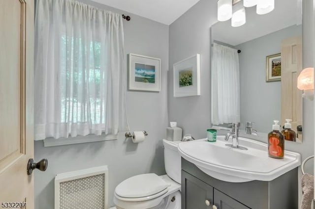 bathroom with toilet, radiator, and vanity