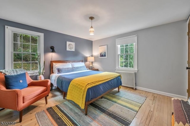 bedroom featuring radiator heating unit and light hardwood / wood-style floors